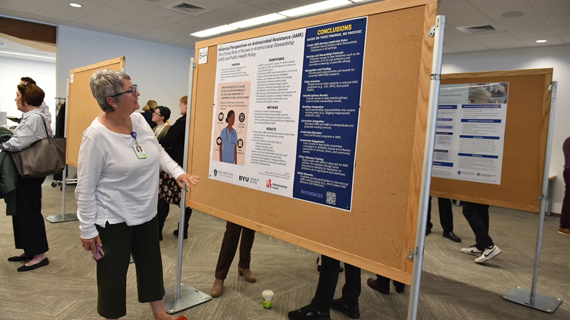 A woman looks at a scientific poster on the role of nurses in antimicrobial stewardship