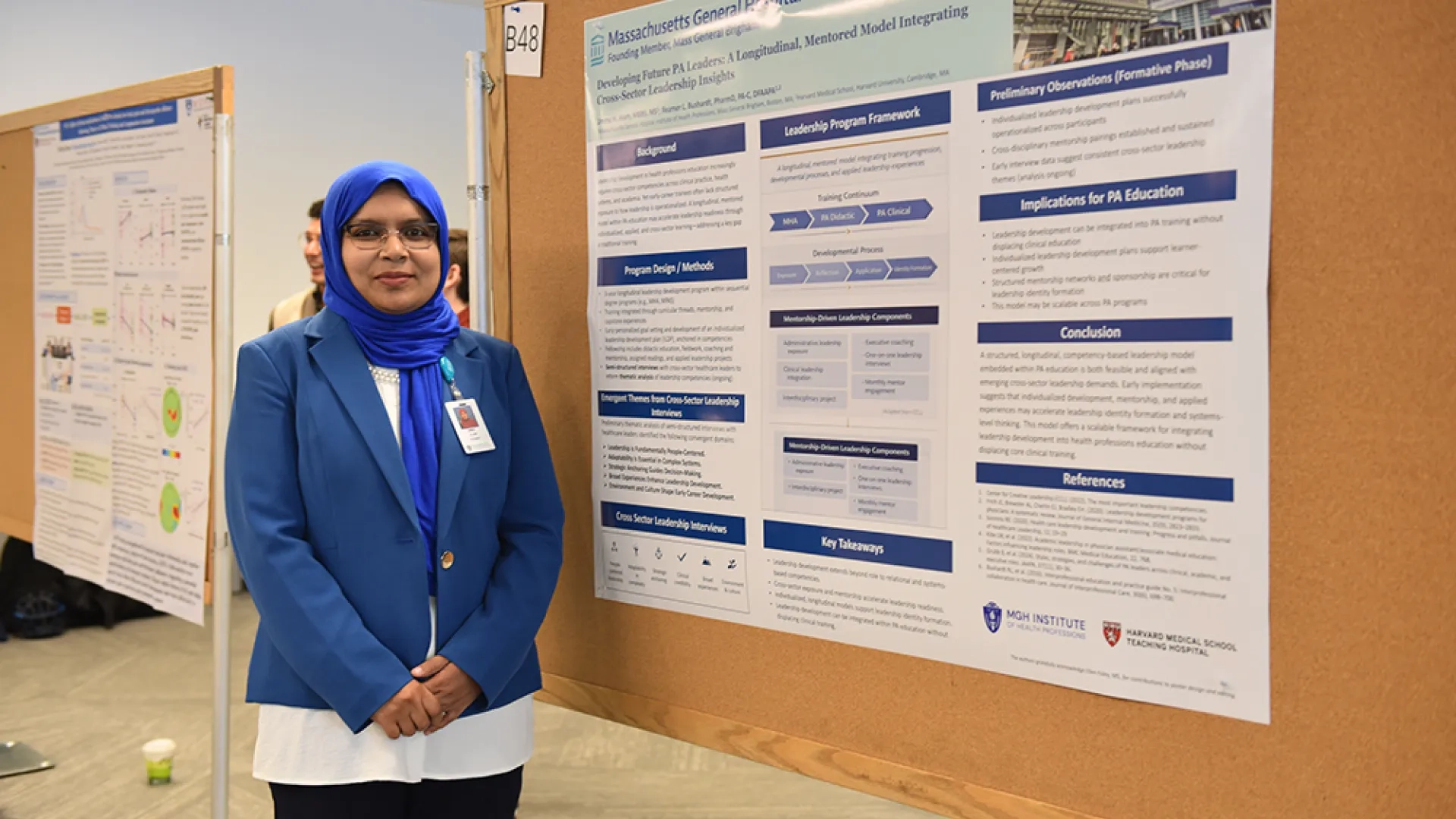 A woman stands in front of a research poster on developing physician assistant leaders