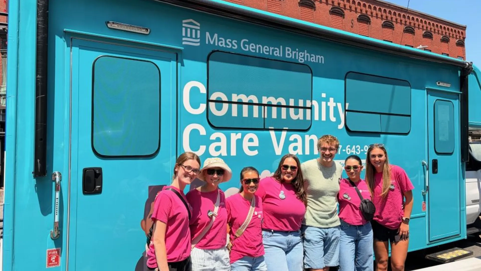 Occupational Therapy students pose in front of a community care van at a Disability Pride event in Chelsea