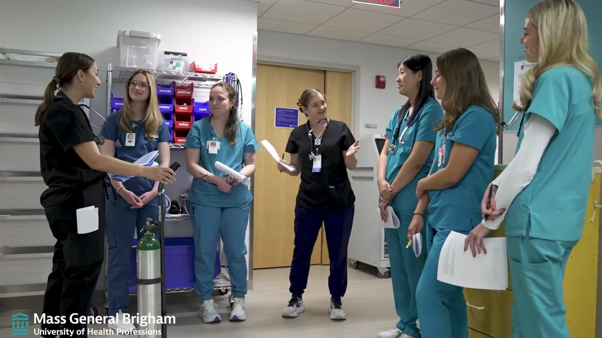 group of nurses in scrubs conferencing a U shape
