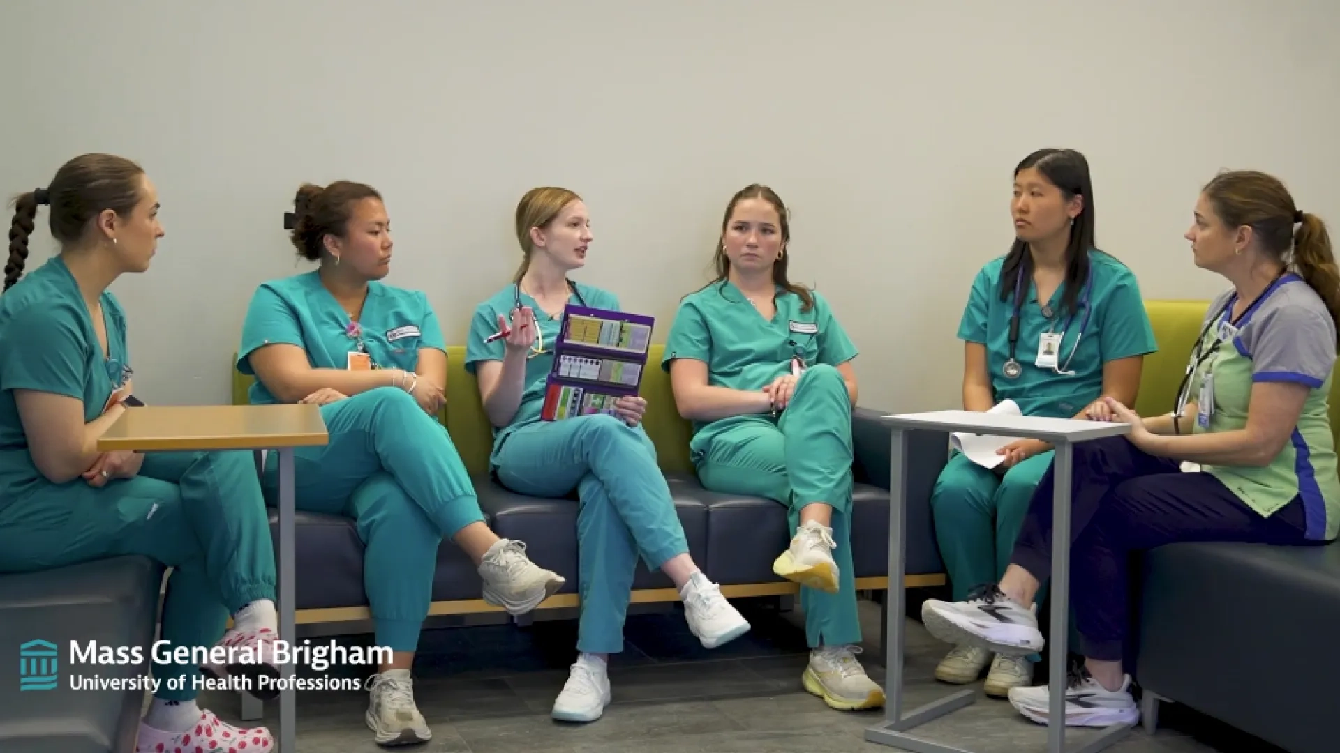 a group of nursing students sits on a U-shaped bench