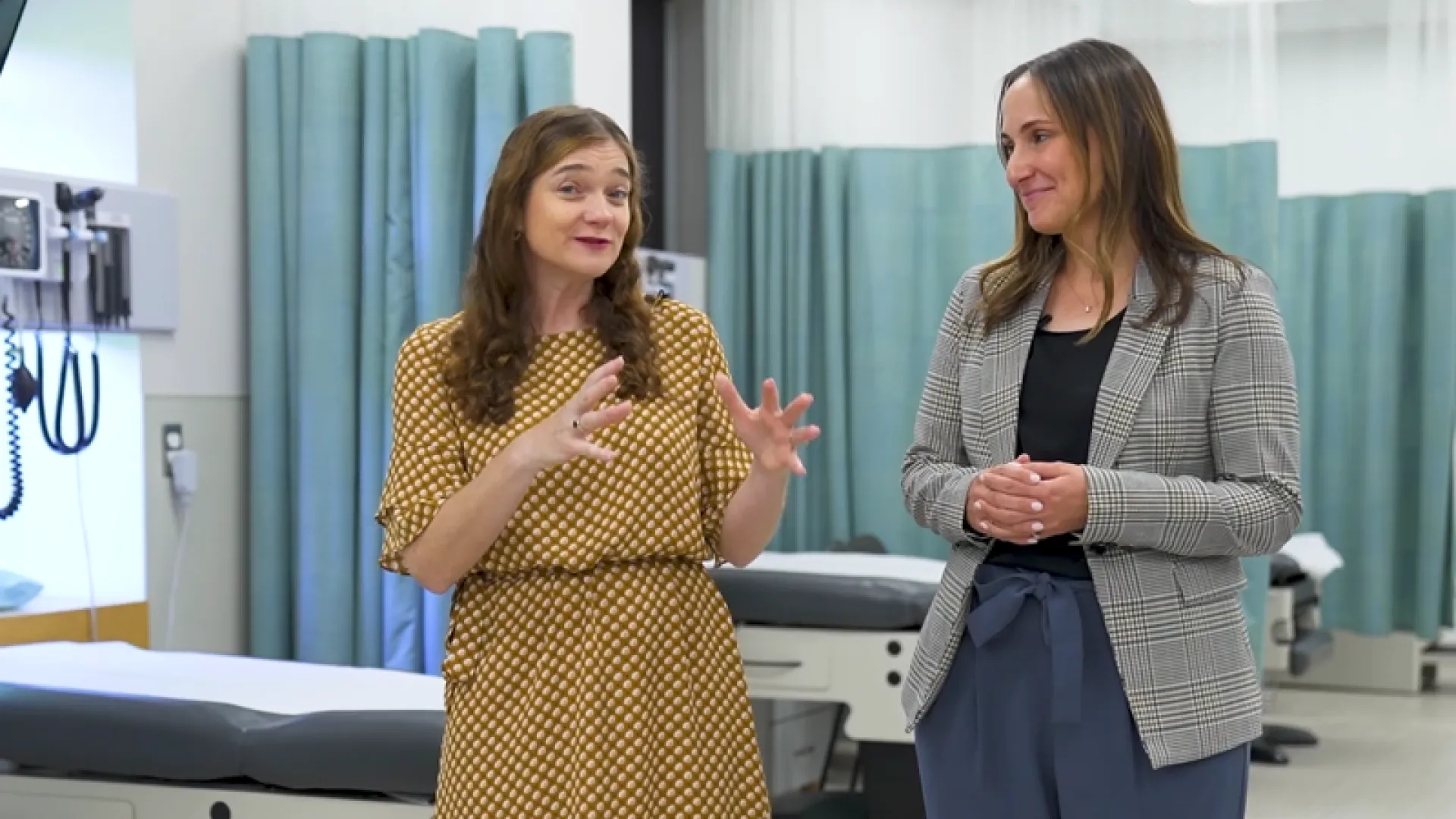 two women stand in a clinical space and talk about the AACN domains