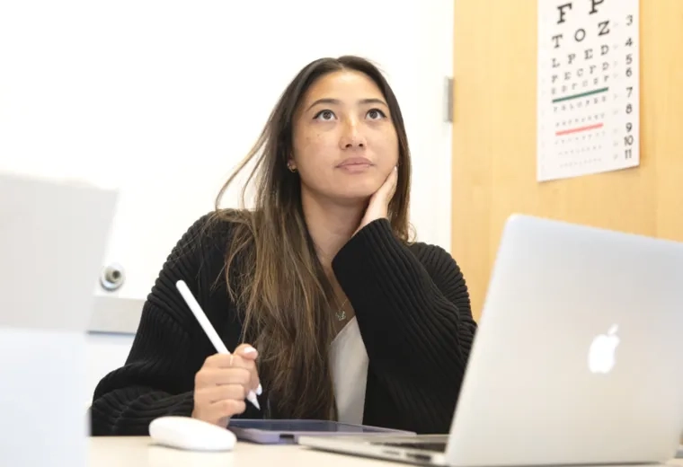 Woman studying at a desk with a laptop and tablet