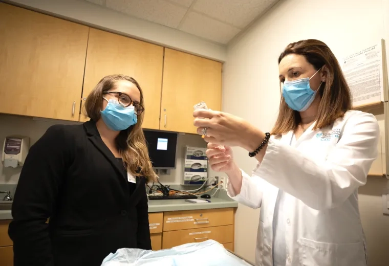 Physician and a woman with masks on in a doctors office