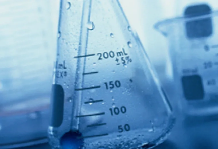 a wet glass jar with measurements on it sits on a table