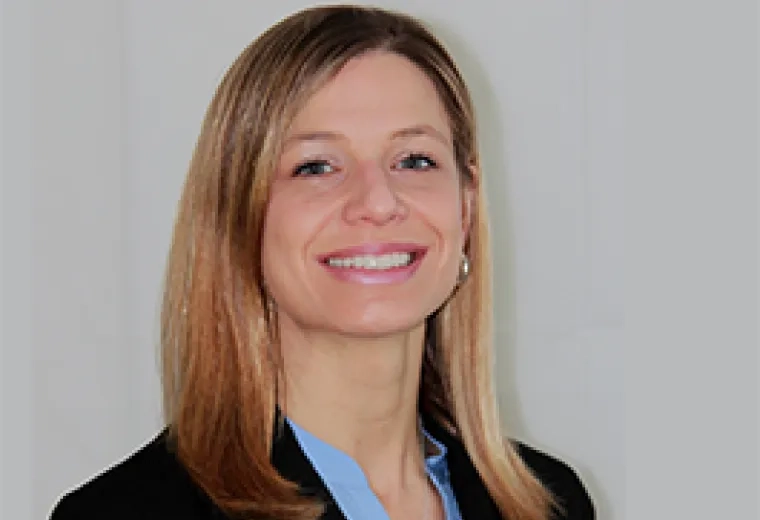 Professional headshot of a Doctor of Occupational Therapy program faculty member with blonde hair, wearing a light blue shirt and black blazer