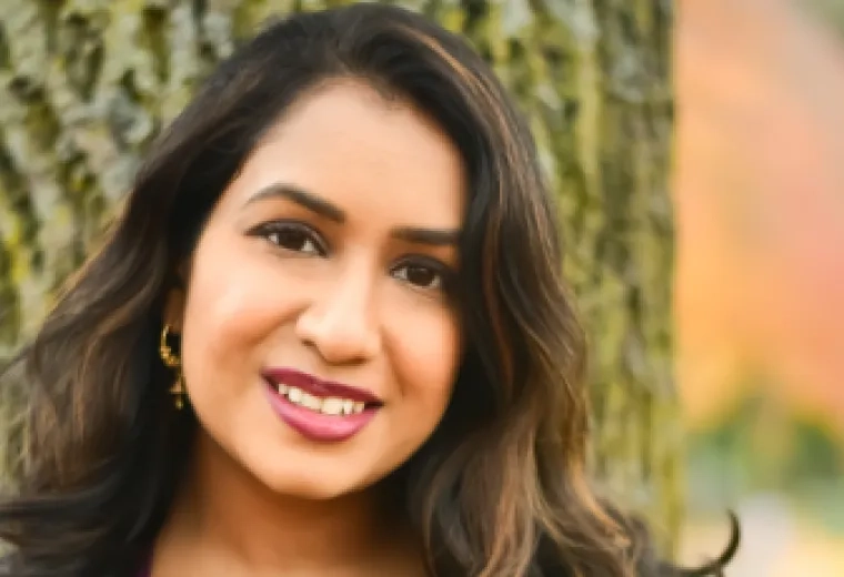 SGA Secretary Swarna Gummadi with a tree and blurred trees behind that.