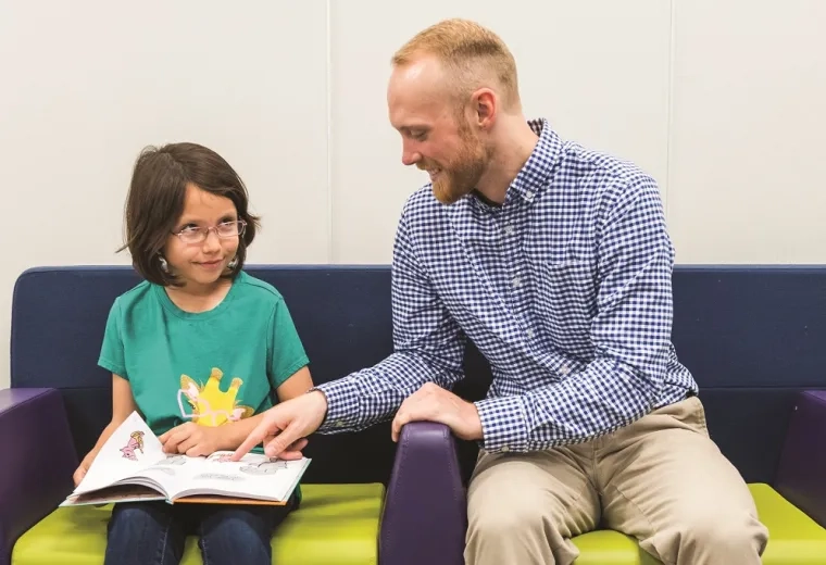 A literacy coach in the MGH IHP Literacy and Language Certificate Program helps a young student with reading comprehension. The program focuses on evidence-based literacy instruction and advanced literacy strategies, preparing educators for reading specialist certification and literacy leadership training.