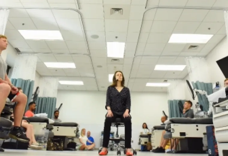 Meghan Viveiros, an instructor of physician assistant studies, begins her class by guiding her students into a state of relaxation.