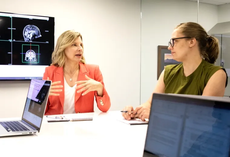 Two woman sitting at a table having a discussion