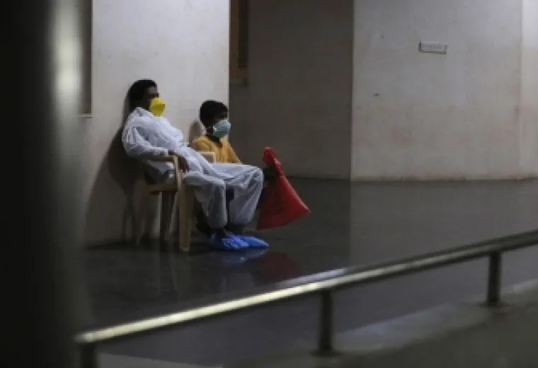 2 people with masks on sitting next to each other