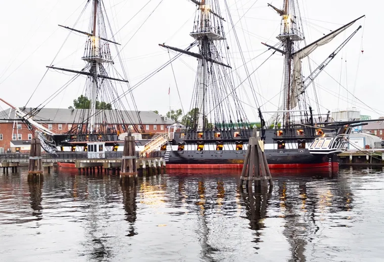 three masted schooner is reflected in the ocean water