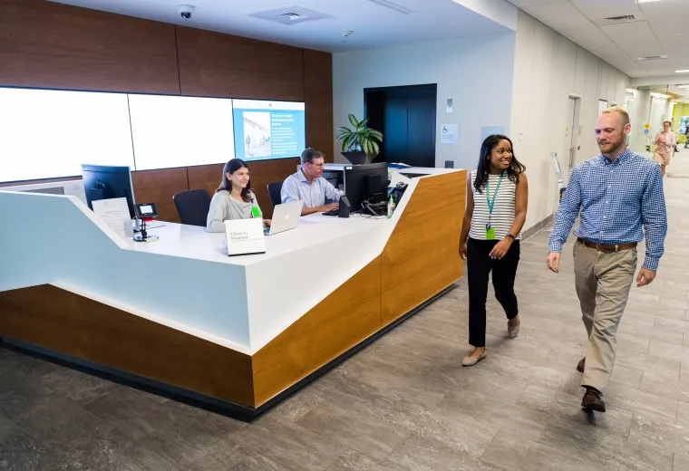 People walking on campus past welcome desk