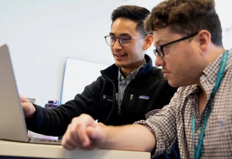 Two students working on a computer together