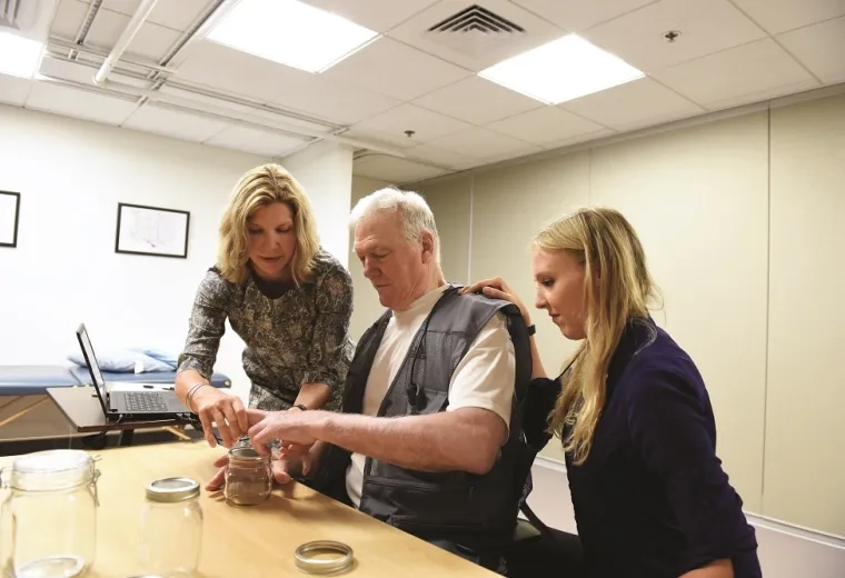 woman helps man put items into a glass ball jar on the table