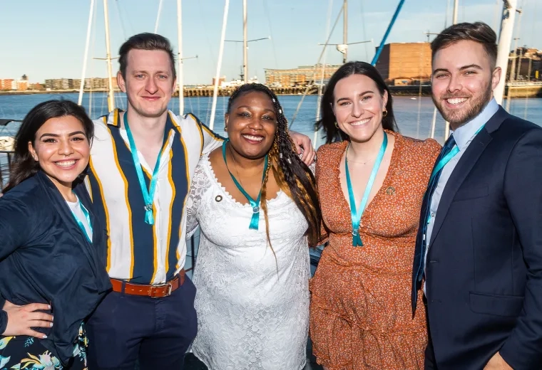 group of men and women in dressed up attire smile for the camera