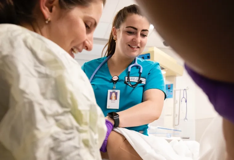 Two nurses wearing scrubs in a hospital room