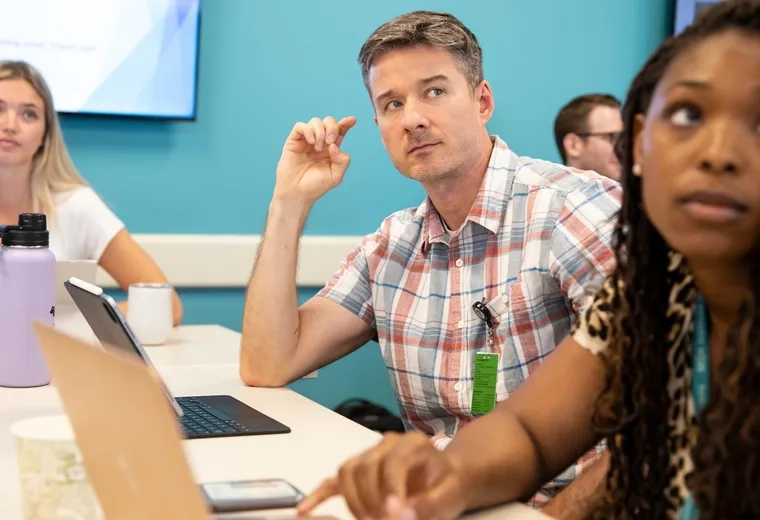 Several people listening to someone speak