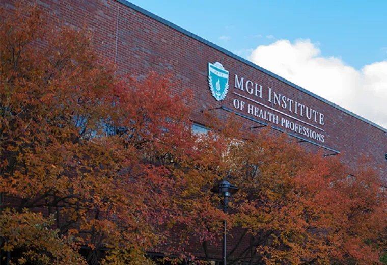 Orange and Red foliage on trees in front of brick building with IHP sign