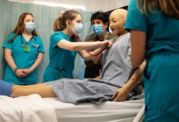Medical professionals training in a hospital room setting
