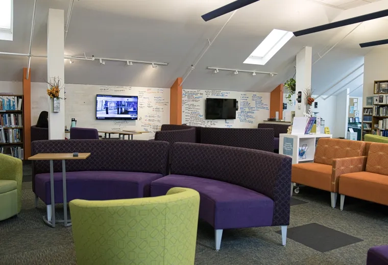 colorful couches - orange, purple and green sit in a room with writing on the walls