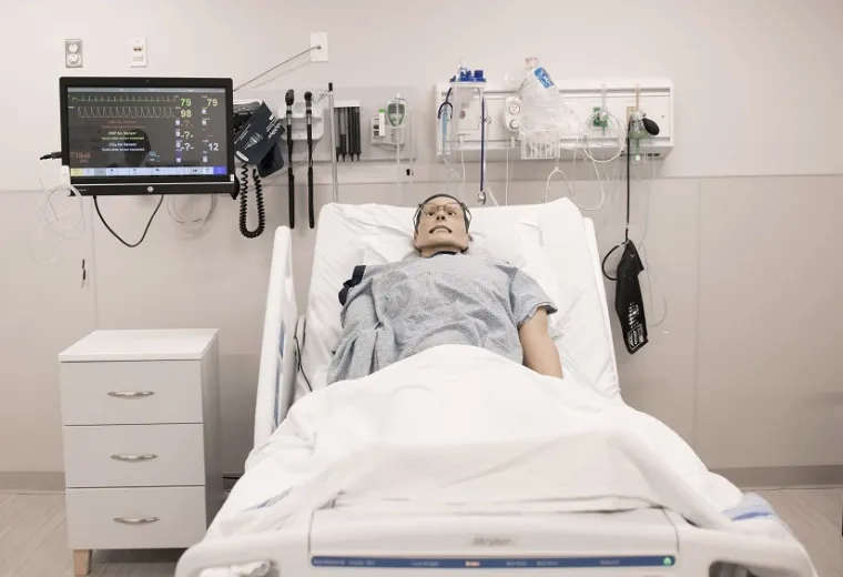 hospital bed with man manikin in it hooked up to monitors