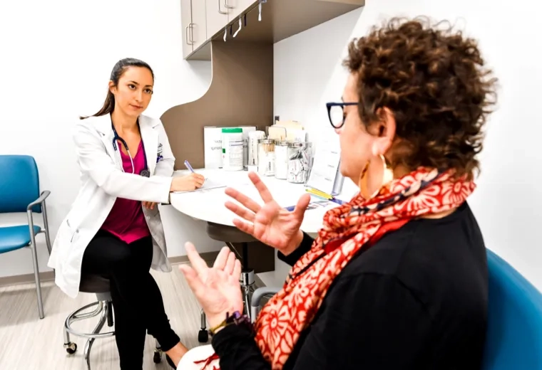 A nurse talking to a patient while taking notes
