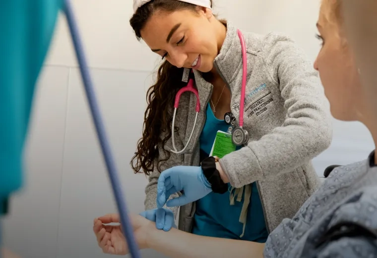 Nursing student helping a patient at MGH IHP's Impact Center.