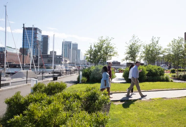 People walking in a park with the waterfront in the backround