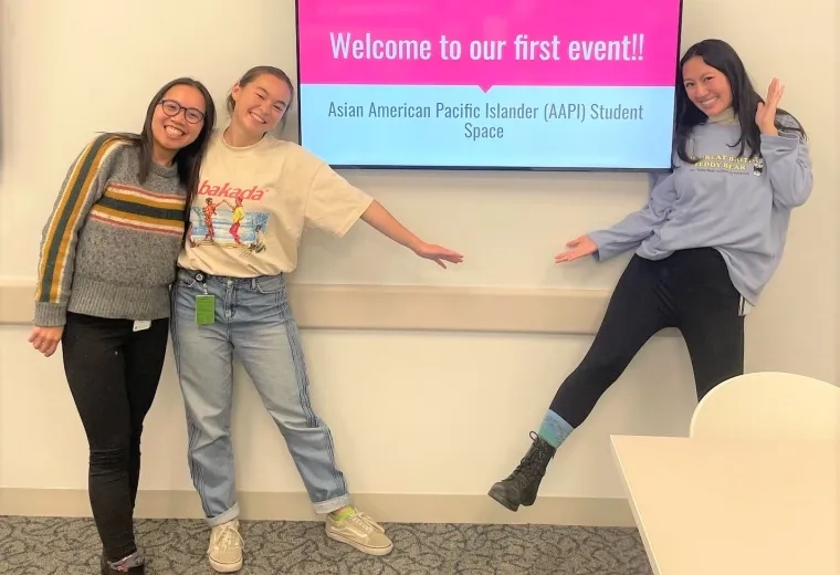 three fellows stand next to a screen that reads welcome to our first event
