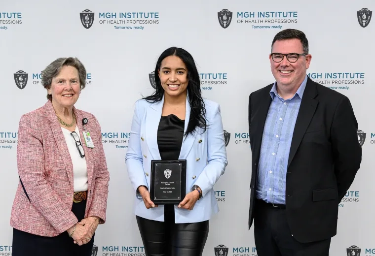 woman in middle with baby blue blazer holds plaque 