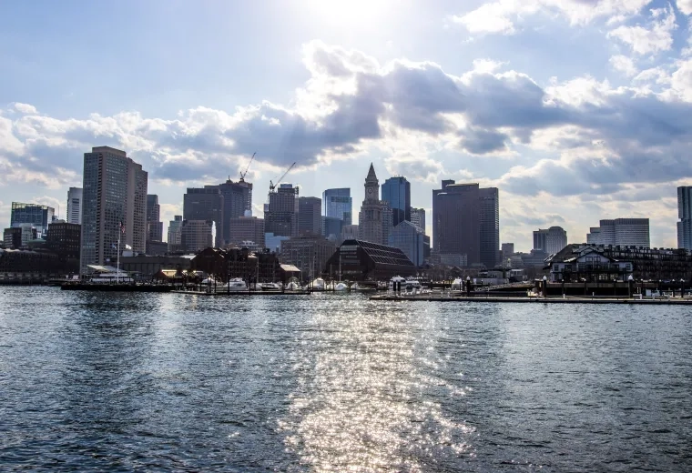 skyline of boston with sparkling ocean water in front of it