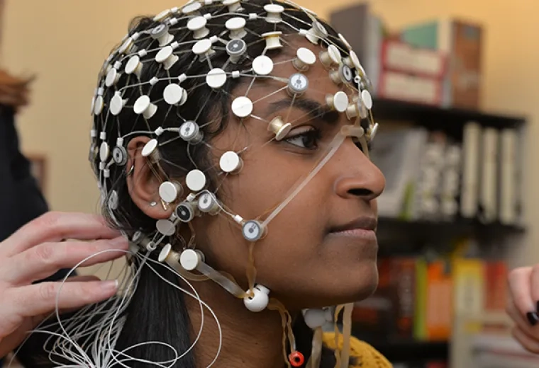 A system of sensors known as an EEG is being placed on the head of an individual