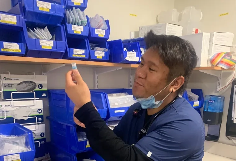 A nurse prepares a syringe.