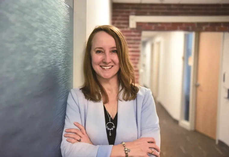profile photo of kathy, she leans against a brick wall