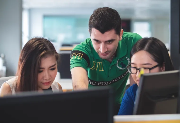 man and two women on laptops