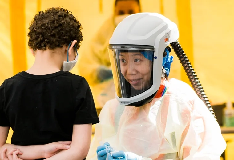 Photo of Julie Chan working with a young patient at the Lynn Community Health Center