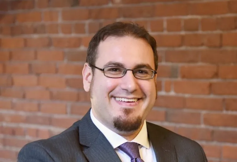 Aaron Hoffman in grey suit and purple tie