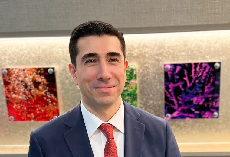 osman wears a blue blazer and red tie