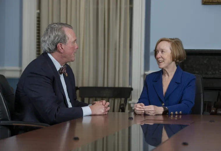 dean white and debbie burke talk across a conference room table