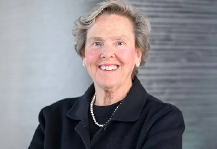 paula wears a dark suit and set of pearls