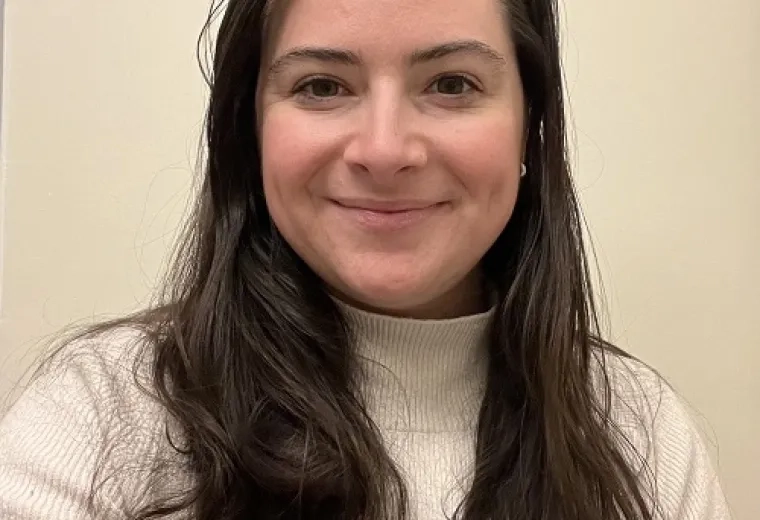 rachel has straight brown hair past her shoulders and wears a cream turtleneck sweater