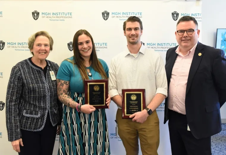 leah and matthew smile and hold matching black, gold and wood plaques 