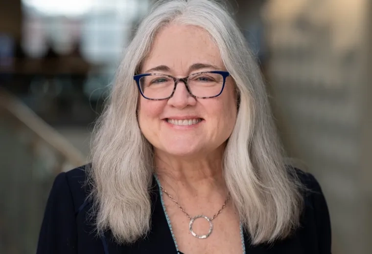 susan has shoulder length grey hair and blue tortoiseshell glasses