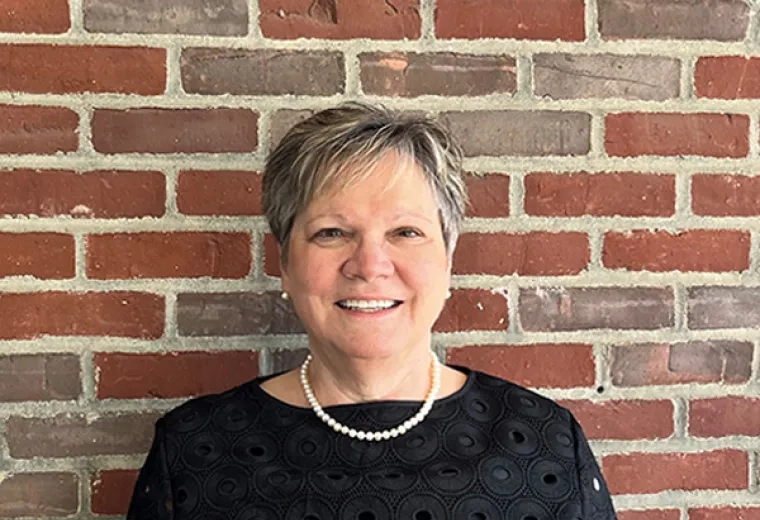 mary stands in front of a brick wall