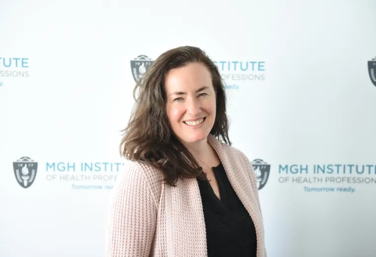 woman stands in front of banner