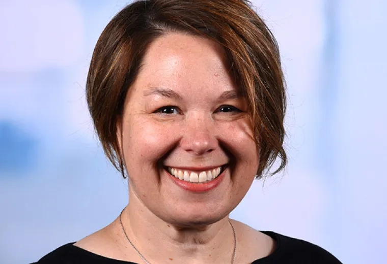 rebecca has short angled brown hair and a big smile