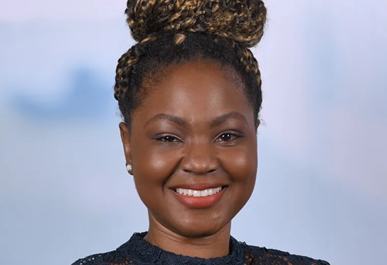 tomisin has a braided bun and a navy lace dress 