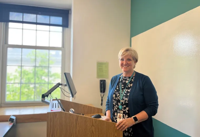 Professor Andrea Pittman stands in front of podium in classroom