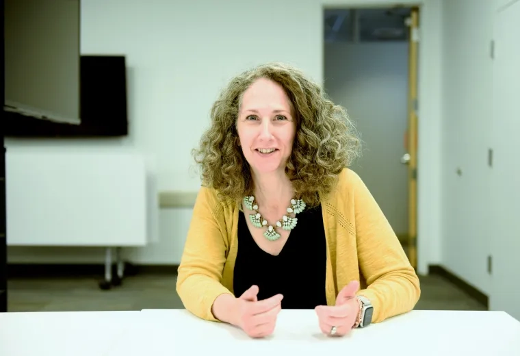 Woman wearing yellow sitting at table